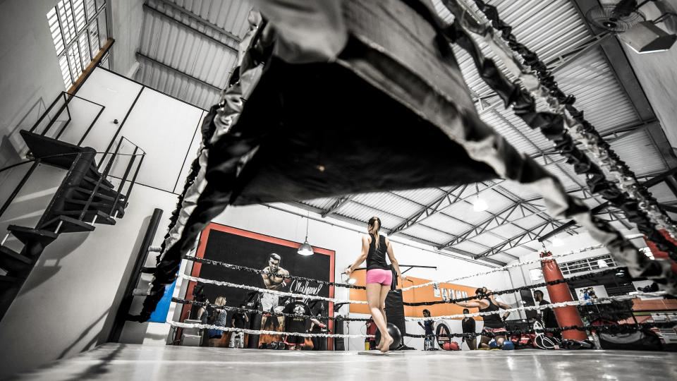 Una palestra di boxe vista dal basso, con il ring e chi si allena.